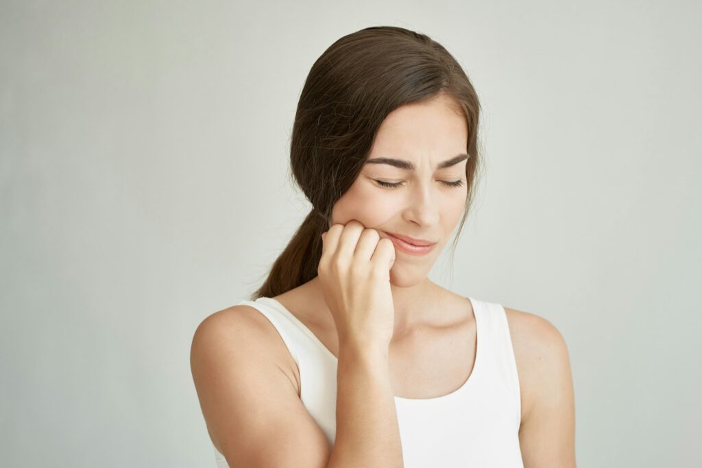 woman in white t-shirt and dental pain health problems dentistry